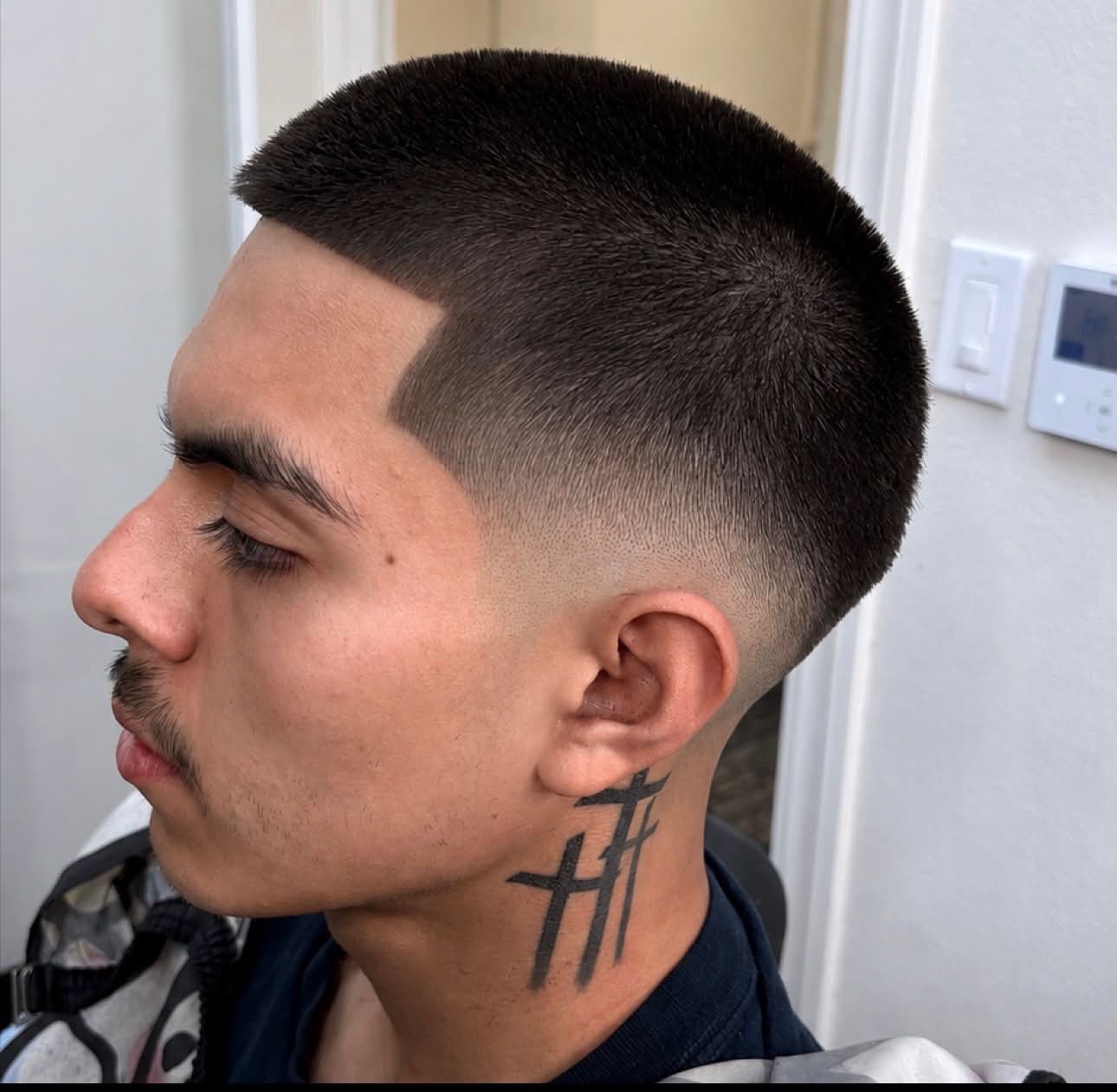 Short buzz cut with a sharp part line, Die4Fadez Barbershop client in National City, CA